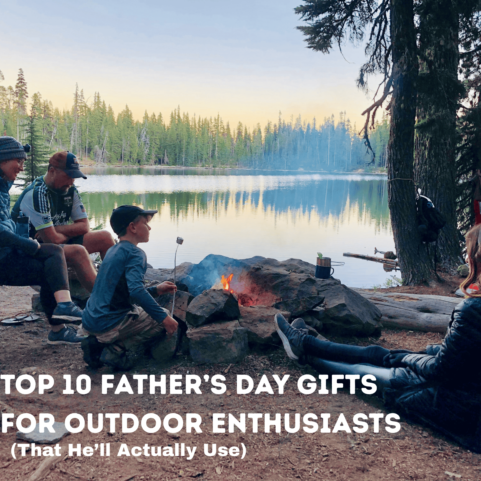 Family sitting by a fire at a campsite by the water